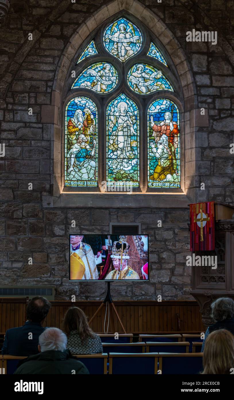 People watching King Charles III coronation on TV screen, St Mary's