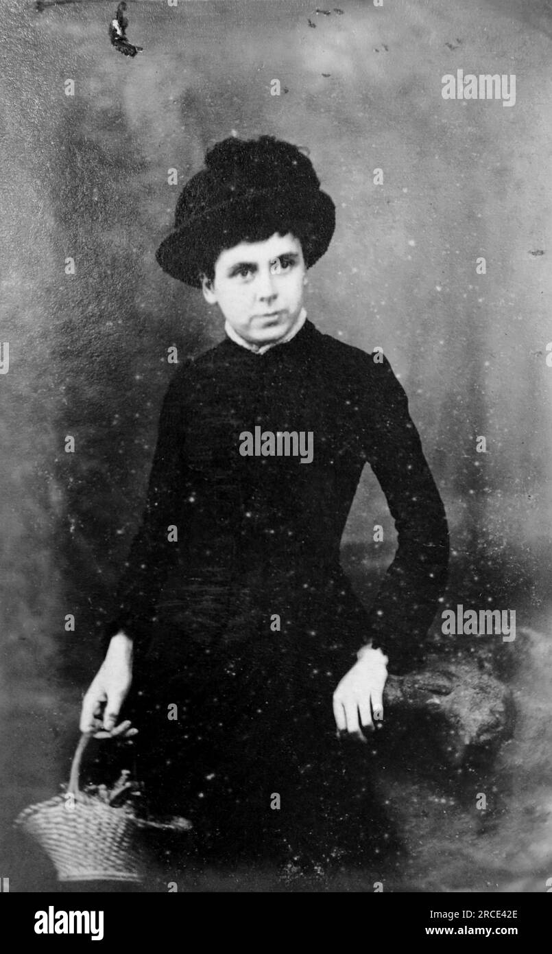 Portrait of a young lady in a black dress and hat standing and holding a basket. Original photograph by J. S. Hazard, 6, Pavement, Clapham Common, London. From a collection of Victorian carte de visite photographs, dated to the 1890s. Carte de visite is a French term known in English as “visiting card”. They usually had an albumen photographic print of about 54x89mm mounted on a slightly larger card. In some cases, the ravages of time have taken their toll. Stock Photo