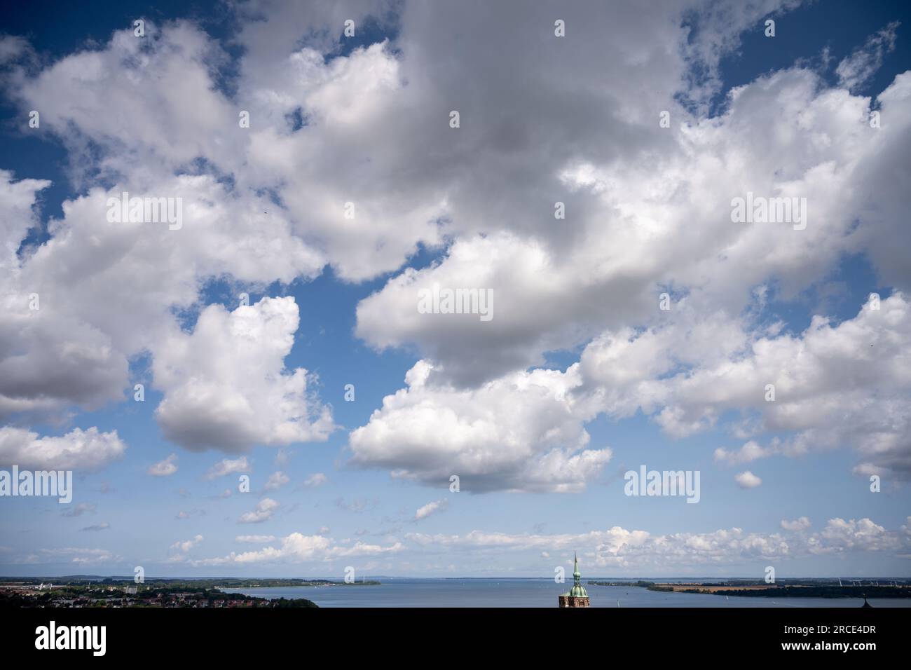 Stralsund, Germany. 14th July, 2023. View from the viewing platform of the clouds above the old town with St. Nicholas Church (back l) to the island of Rügen behind the Strelasund. First mentioned in 1234, the Hanseatic city of Stralsund is one of the tourist magnets in Mecklenburg-Western Pomerania because of its more than 800 listed buildings, most of which have been extensively restored in recent years. Credit: Stefan Sauer/dpa/ZB/dpa/Alamy Live News Stock Photo