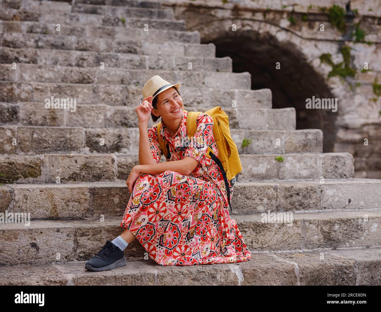 Rhoades Steps Young Asian woman in red dress walks through streets of Rhodes. woman ...
