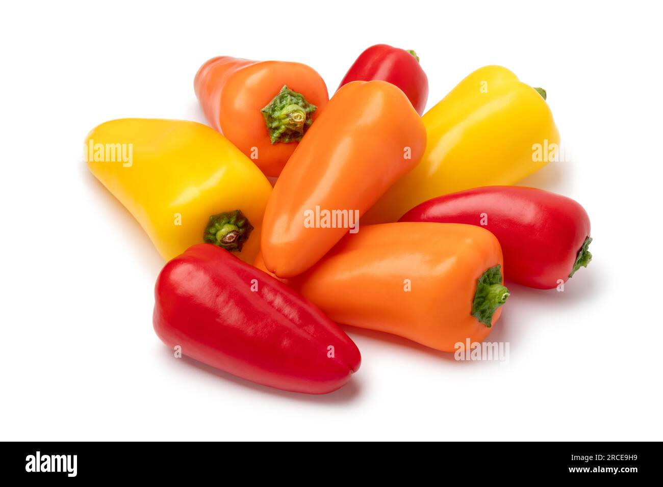 Heap of fresh small colorful snack bell peppers close up isolated on white background Stock Photo