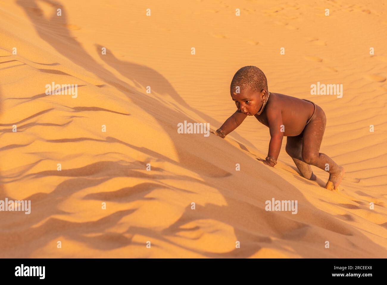 Himba people photoshoot on Sand Dunes near Serra Cafema Camp in Namibia Stock Photo