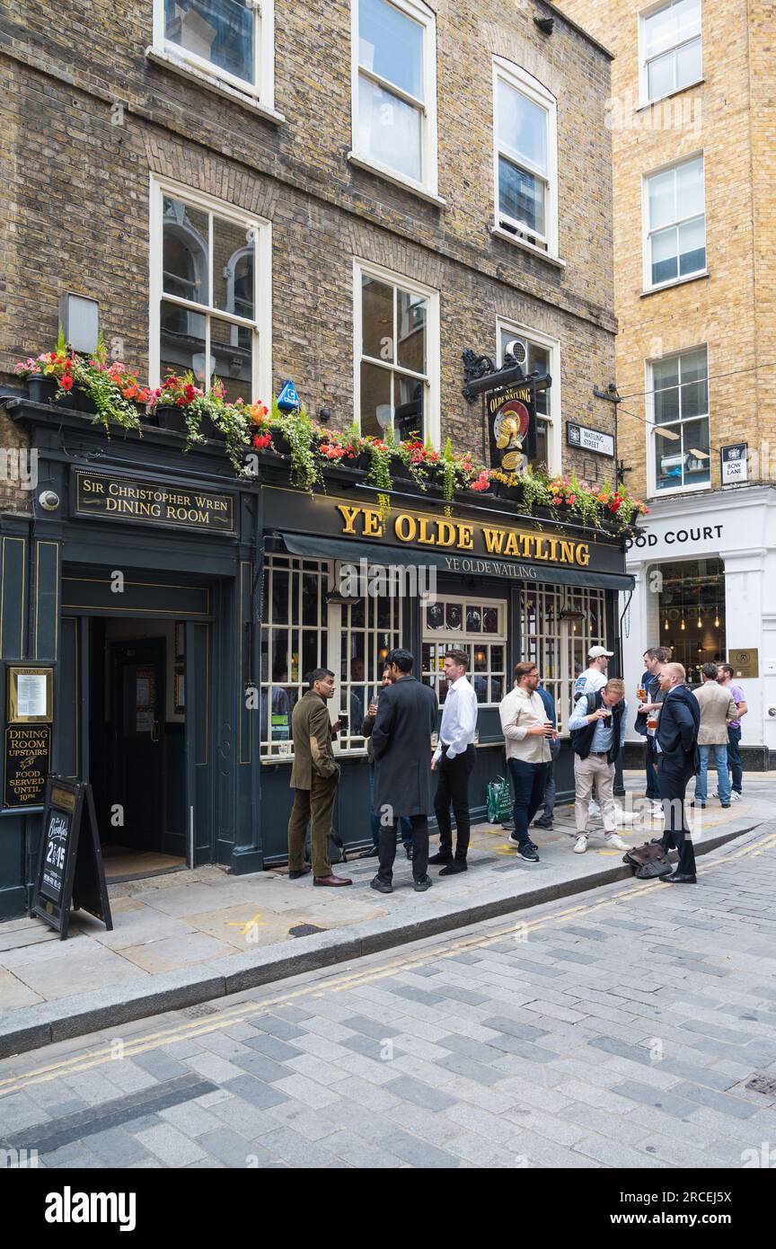 People out and about at lunch time. Groups of men standing and drinking outside Ye Olde Watling pub. Watling Street, City of London, England UK Stock Photo