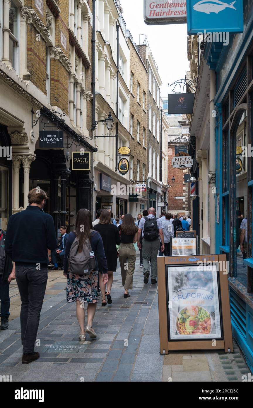 City of London workers walking in Bow Lane, a narrow lane lined with shops and cafes and one of the oldest surviving lanes in the city, England, UK Stock Photo