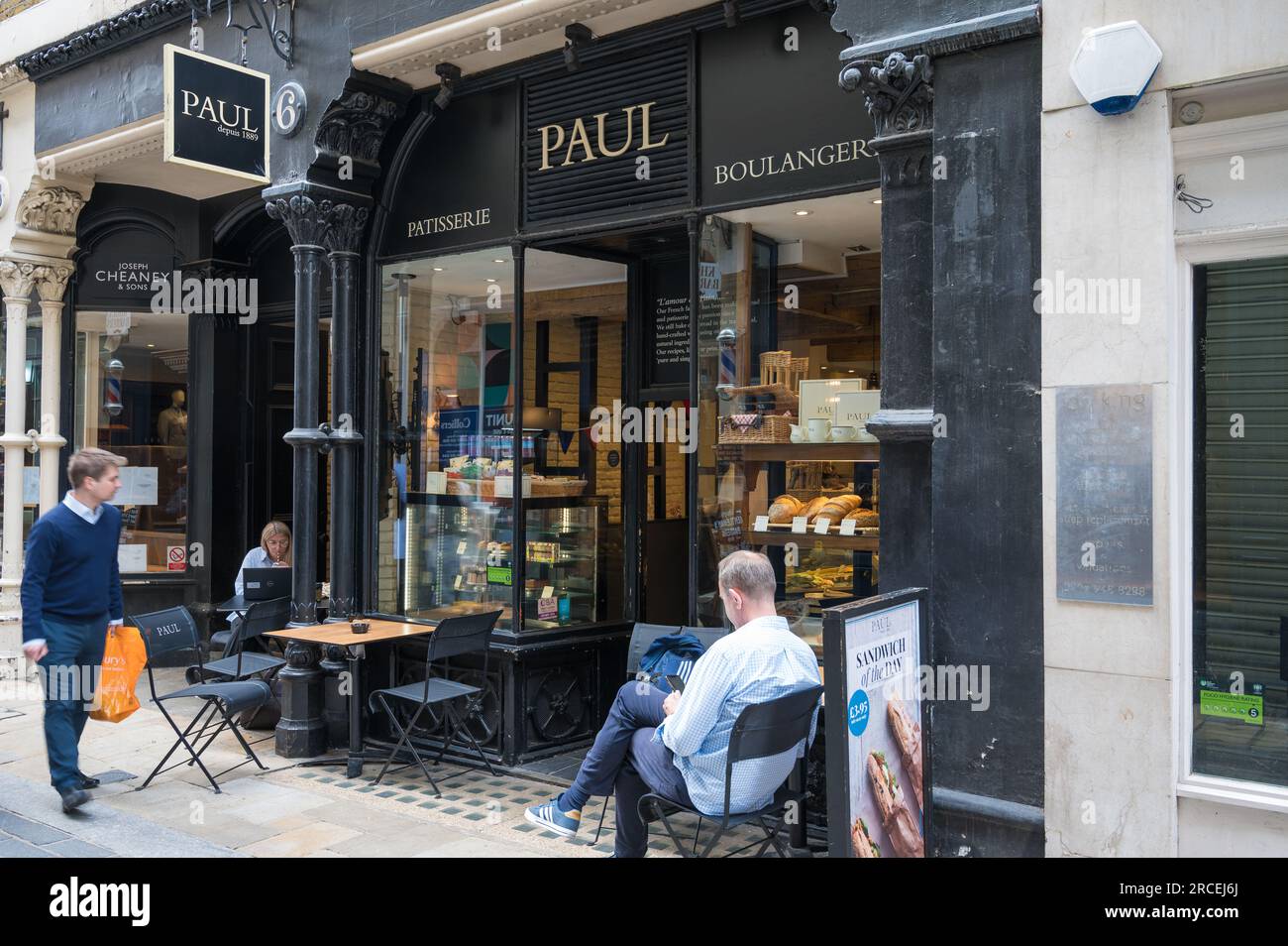 Man and woman sit outside PAUL bakery and sandwich shop in Bow Lane