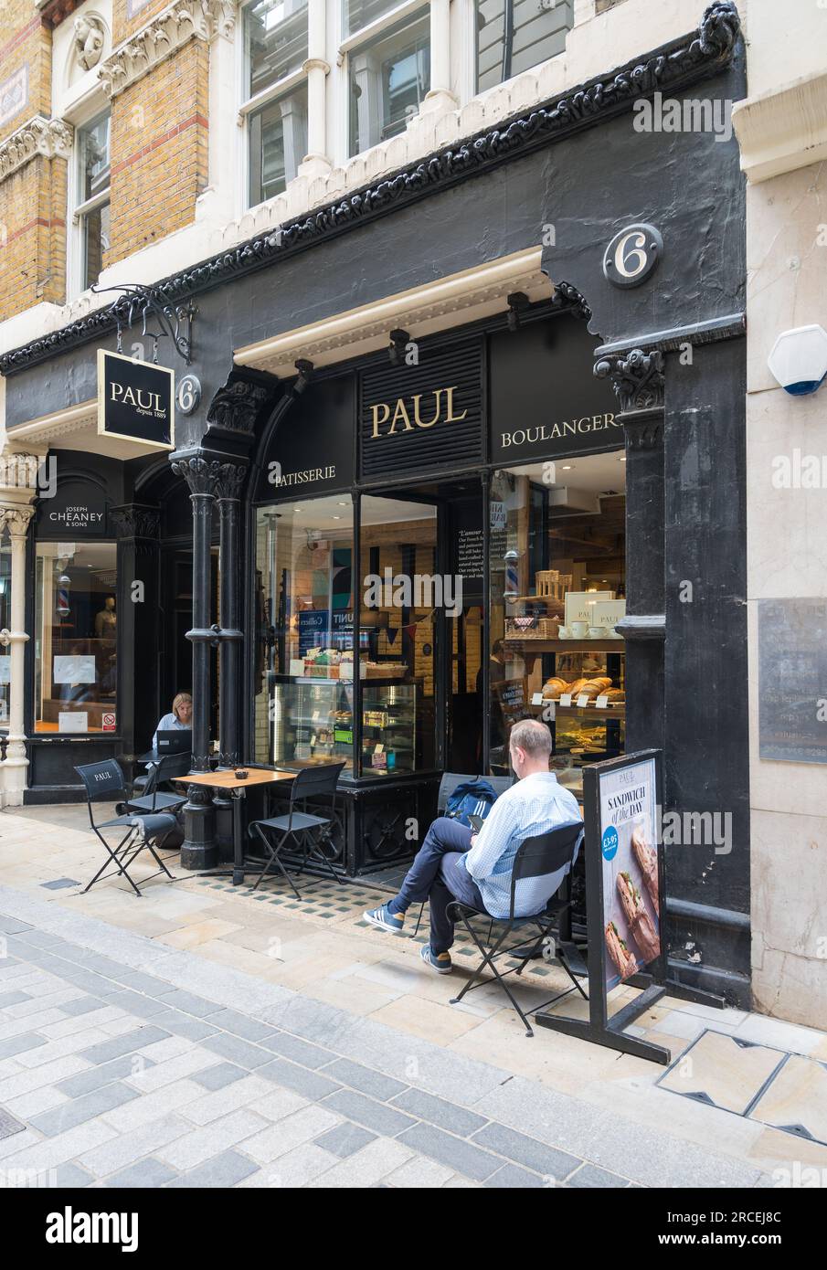 Man and woman sit outside PAUL bakery and sandwich shop in Bow Lane