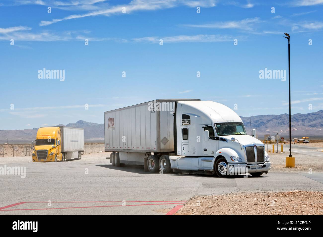 Kenworth and Freightliner American Semi conventional trucks at a truck stop in Nevada USA Stock Photo