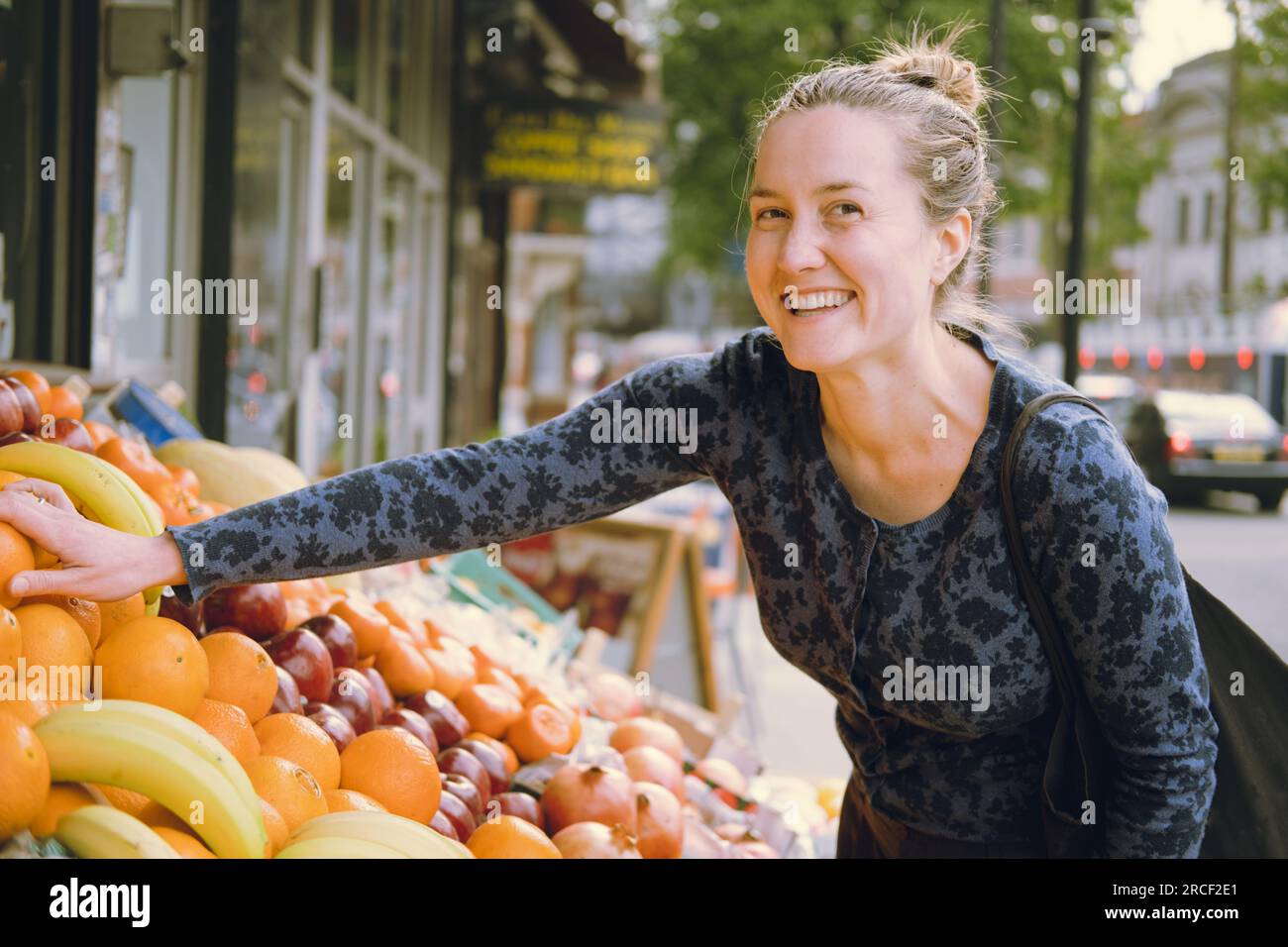 Female youngadult laughing and touching oranges with her right hand
