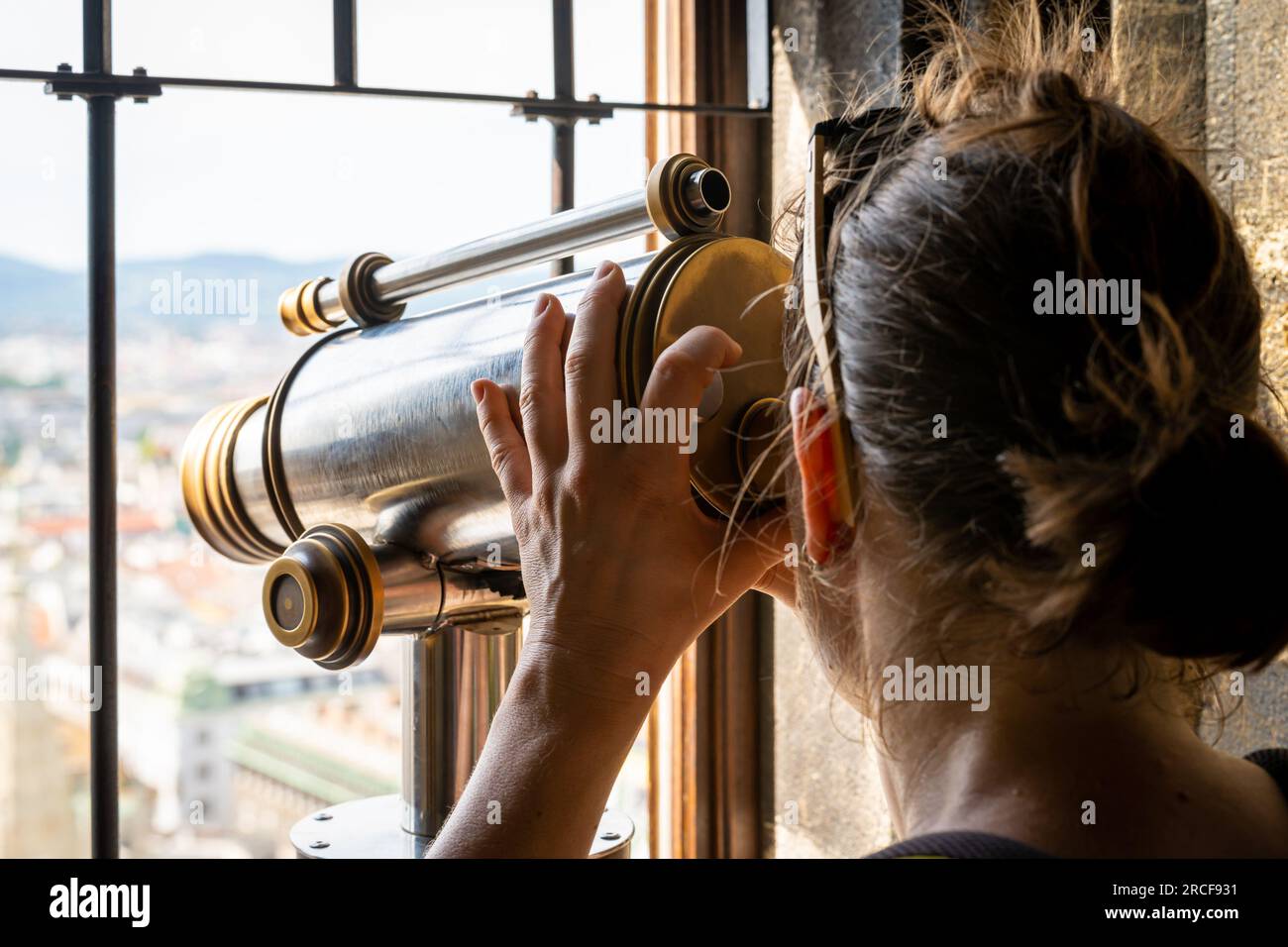 Tourist looks through the telescope from the top of the church tower, selective focus Stock Photo