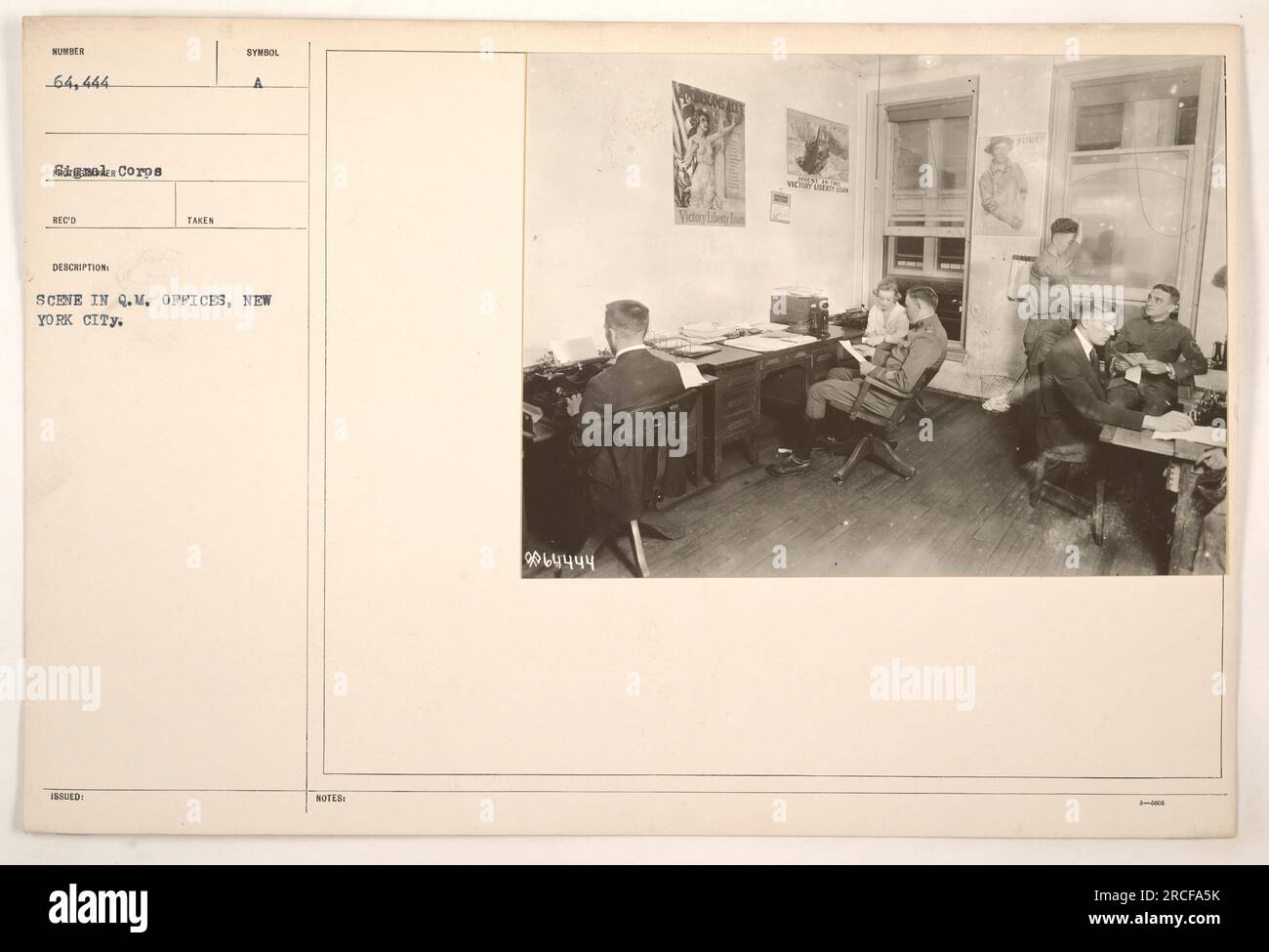 A photo depicting a scene at the Quarter Master (Q.M.) offices in New York City. It is numbered 64,444 and was taken to document American military activities during World War One. The photo captures the environment of the Q.M. offices, showing personnel engaged in their work. Stock Photo
