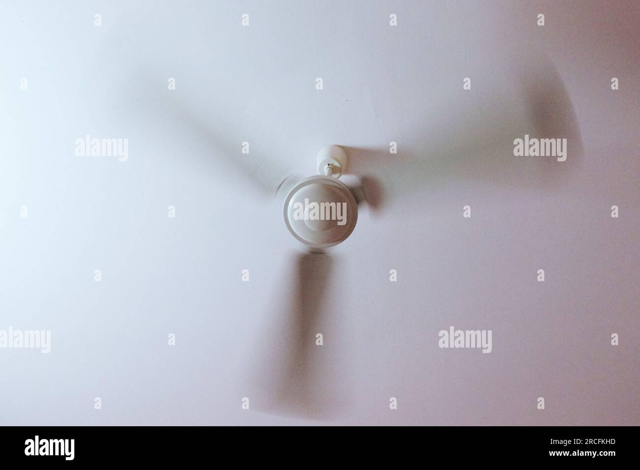 A large fan rotates the blades on the ceiling, motion blur Stock Photo