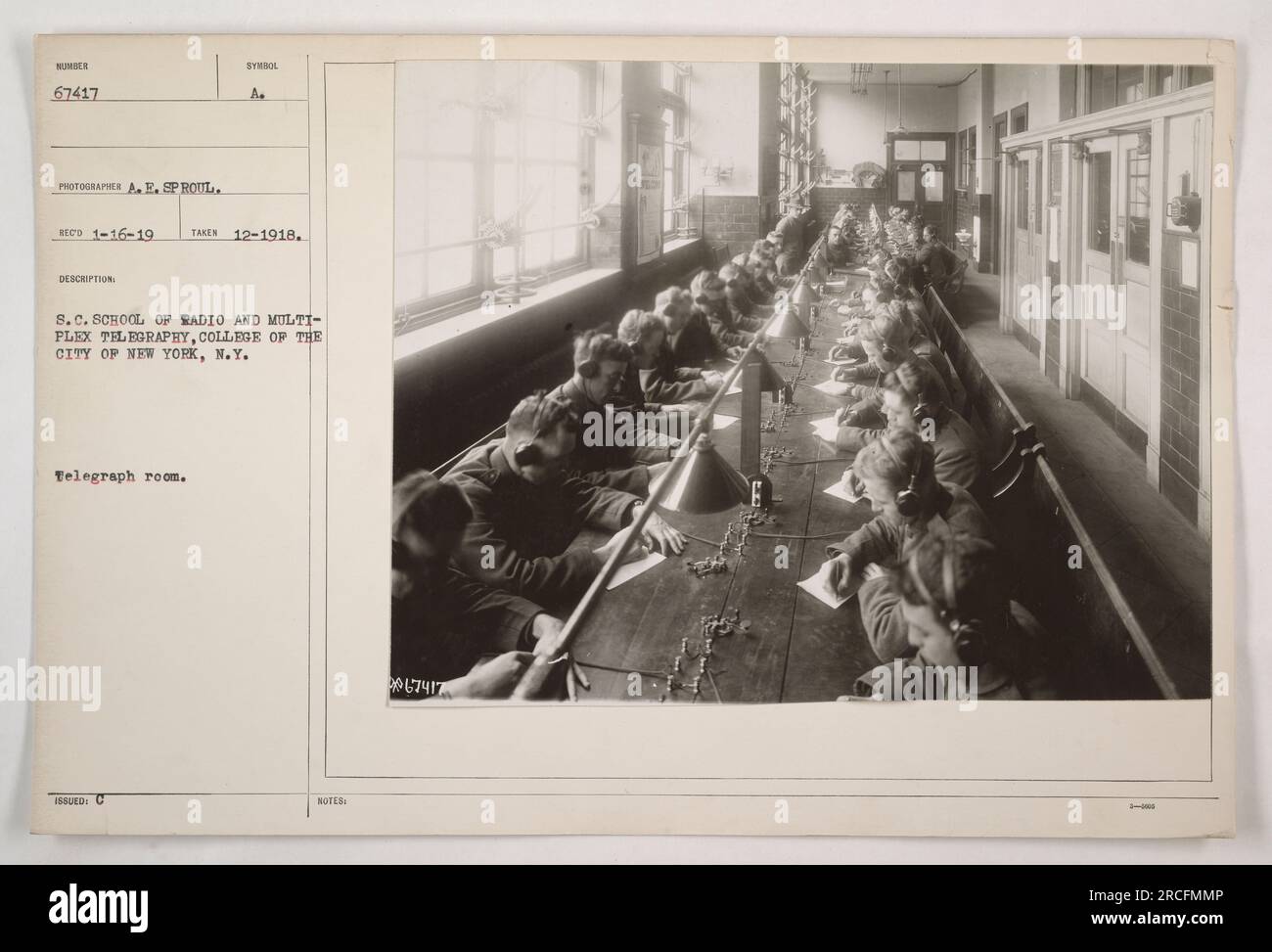 Caption: 'Photograph taken in December 1918 at the S.C. School of Radio and Multiplex Telegraphy, located in the College of the City of New York, New York. The image captures a telegraph room, identified by the symbol 'C.A.S.' (presumably for the school), where students are seen practicing telegraphy.' Stock Photo