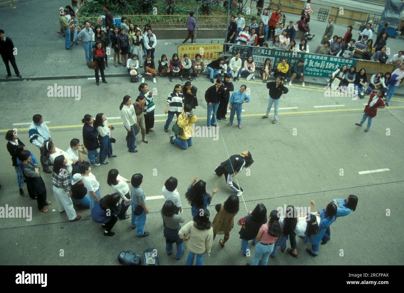 Working and migrants women from the Philippines meet on a sunday on a closed road in the city of Hongkong in Hongkong.  China, Hongkong, October, 1996 Stock Photo