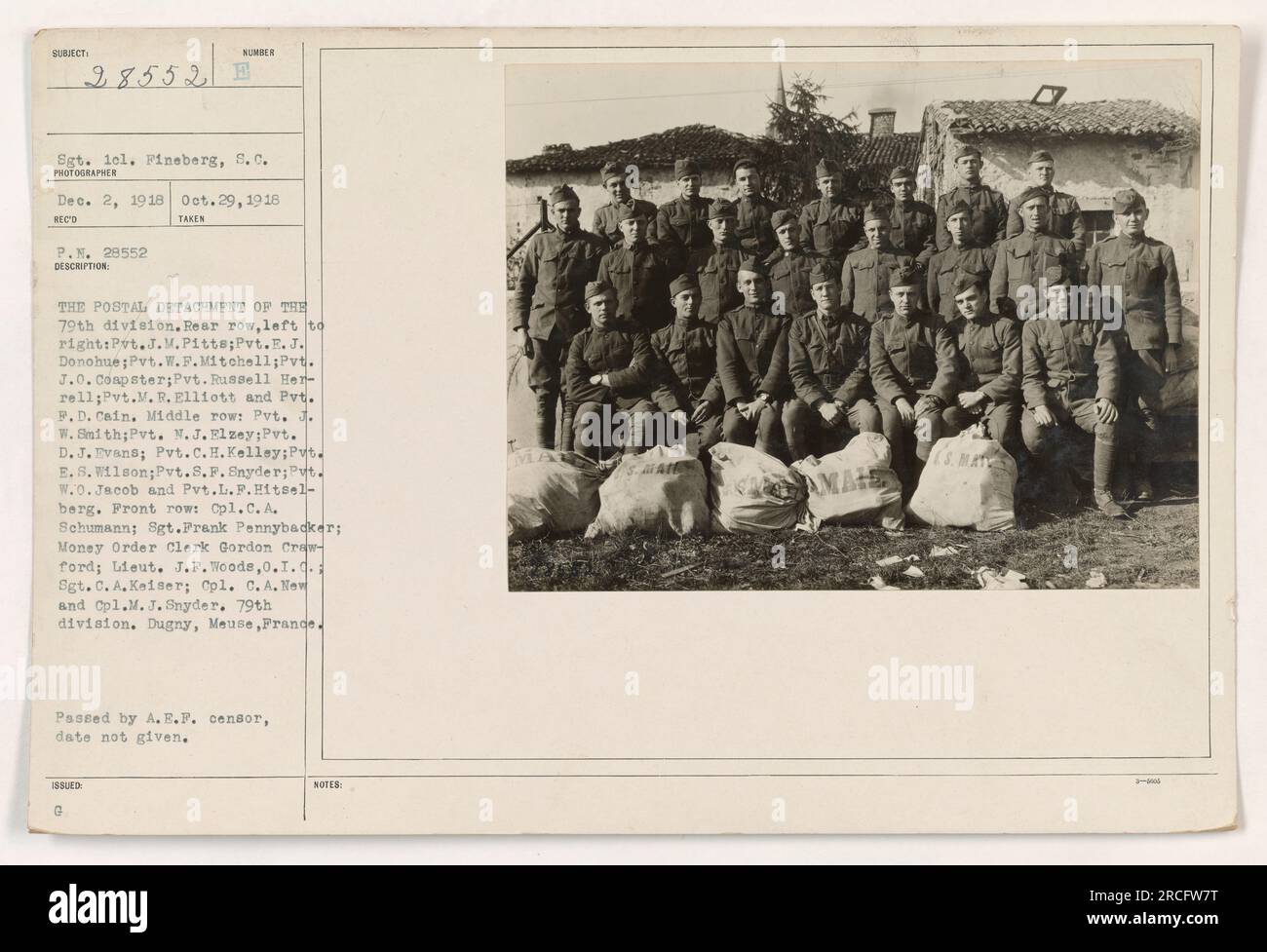 Postal Detachment of the 79th division. Back row: Pvt. J.M.Pitts, Pvt.E. J. Donohue, Pvt.W.F.Mitchell, Pvt. J.0. Coapster, Pvt. Russell Herrell, Pvt.M. R. Elliott, Pvt. P. D. Cain. Middle row: Pvt. J. W. Smith, Pvt. M.J. Elzey, Pvt. D. J. Evans, Pvt.C.H. Kelley, Pvt. E.S. Wilson, Pvt.S.P. Snyder, Pvt. W.0. Jacob, Pvt.L.F.Hitselberg. Front row: Cpl.C. A. Schumann, Sgt.Prank Pennybacker, Money Order Clerk Gordon Crawford, Lieut. J.F. Woods, Sgt. C. A. Keiser, Cpl. C.A. New, Cpl.M. J. Snyder. 79th division, Dugny, Meuse, France. Photograph taken on October 29, 1918. (Photographer: Sgt. 1el. Fineb Stock Photo