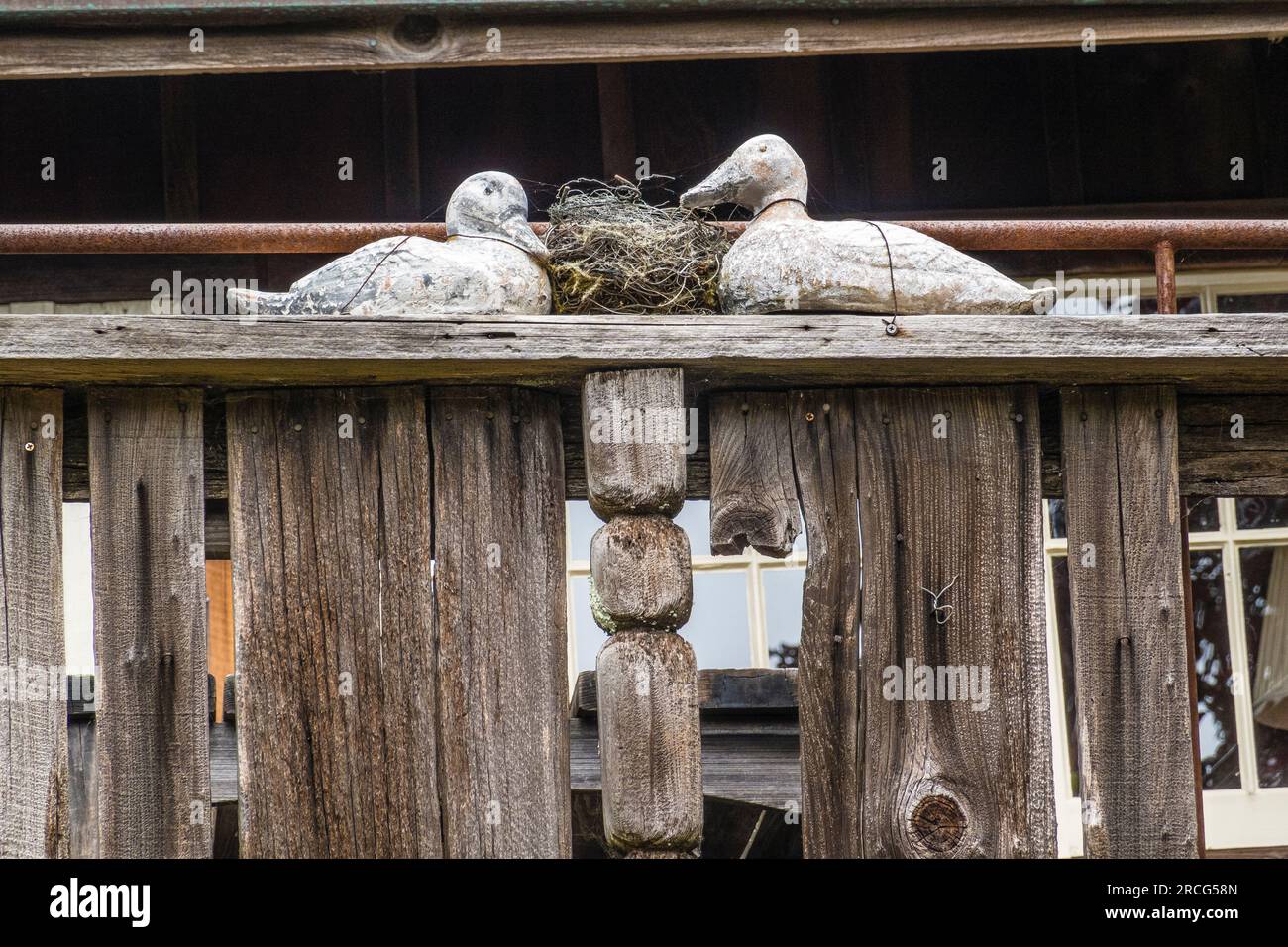 Two wooden ducks display on top of a rustic wooden balcony at Deetjen's Big Sur Inn located on