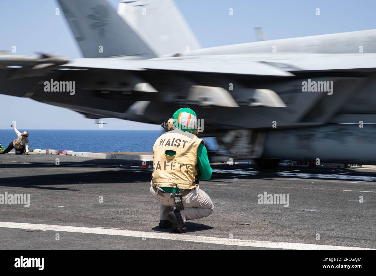 Chief Warrant Officer 3 Anthony Dellajaccono, assigned to the worldÕs largest aircraft carrier USS Gerald R. FordÕs (CVN 78) air department, performs waist safety as an F/A-18E Super Hornet, assigned to the ÒGolden WarriorsÓ of Strike Fighter Squadron (VFA) 87, launches from the flight deck, July 12, 2023. VFA 87 is deployed aboard Gerald R. Ford as part of Carrier Air Wing (CVW) 8. The Gerald R. Ford Carrier Strike Group (GRFCSG)  is participating in Neptune Strike, a multiyear effort focused on harmonizing U.S. and NATO planning teams to transfer command and control of Allied naval and amphi Stock Photo