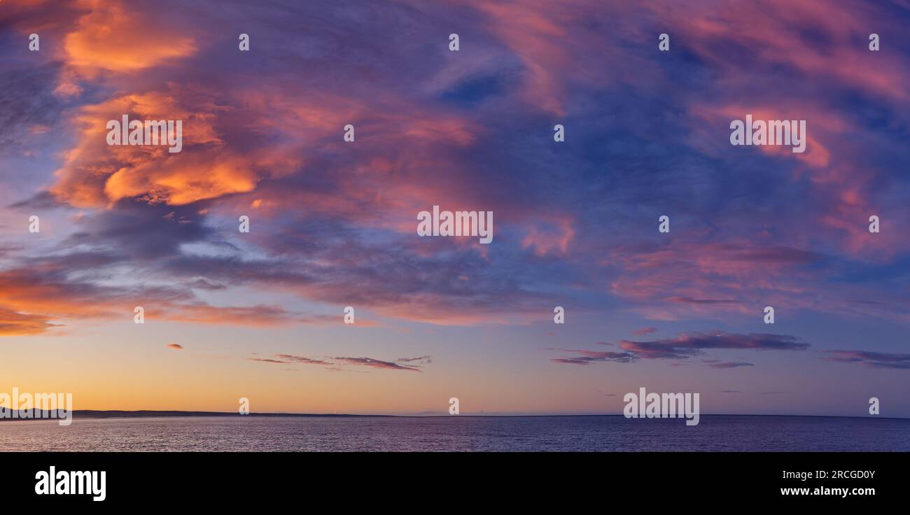 Sunset on granite rocks along the coast with orange lichen at Binalong