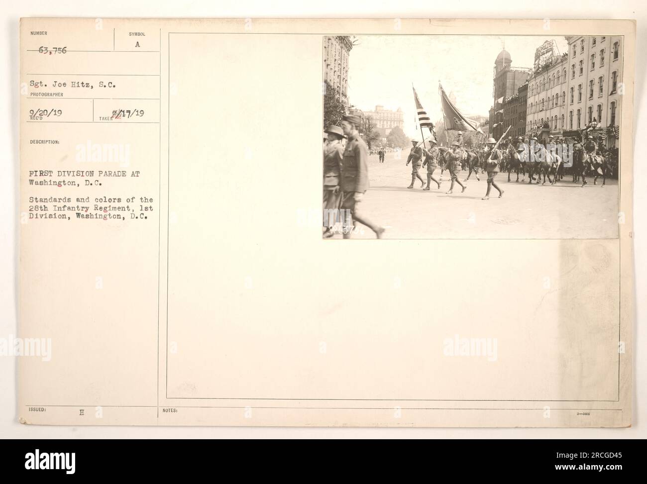 A photograph featuring a parade of the First Division in Washington, D.C. The image shows the standards and colors of the 28th Infantry Regiment, 1st Division. Sergeant Joe Hitz took the photo on February 20, 1919. The description indicates the presence of 63,756 men in the parade. Stock Photo