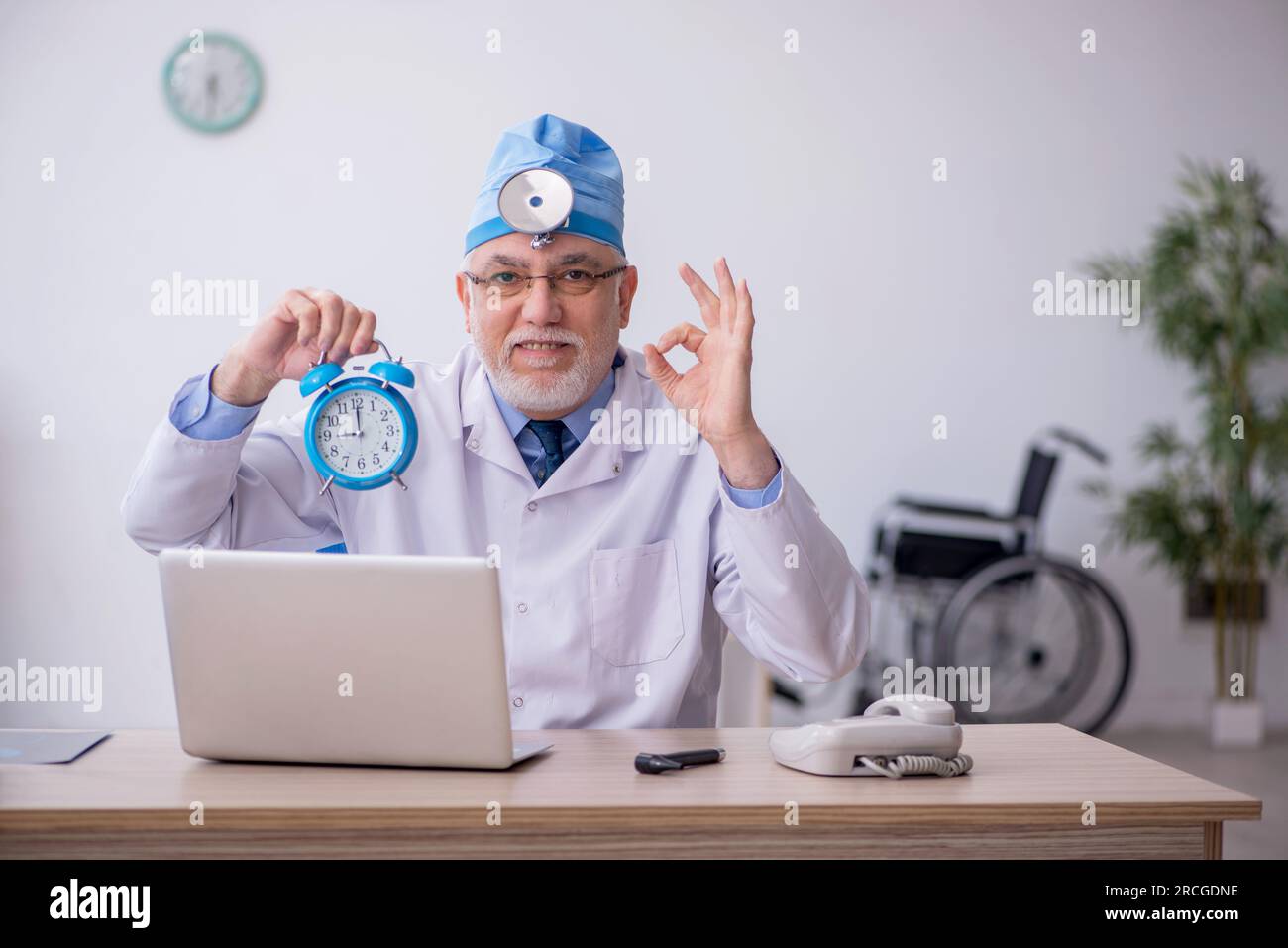 Old docror otolaryngologist working at the hospital Stock Photo