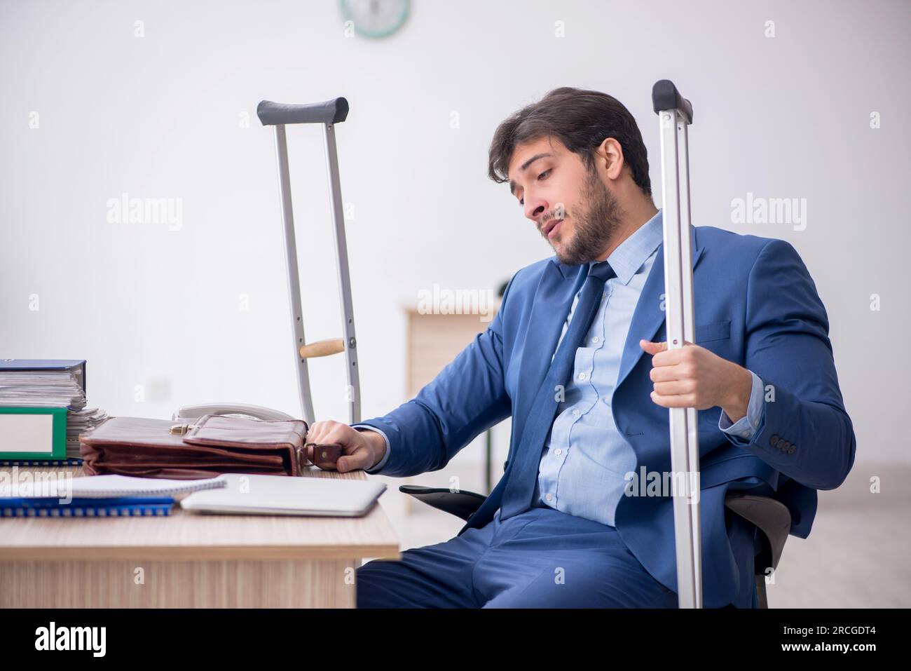 Young employee after car accident sitting at workplace Stock Photo
