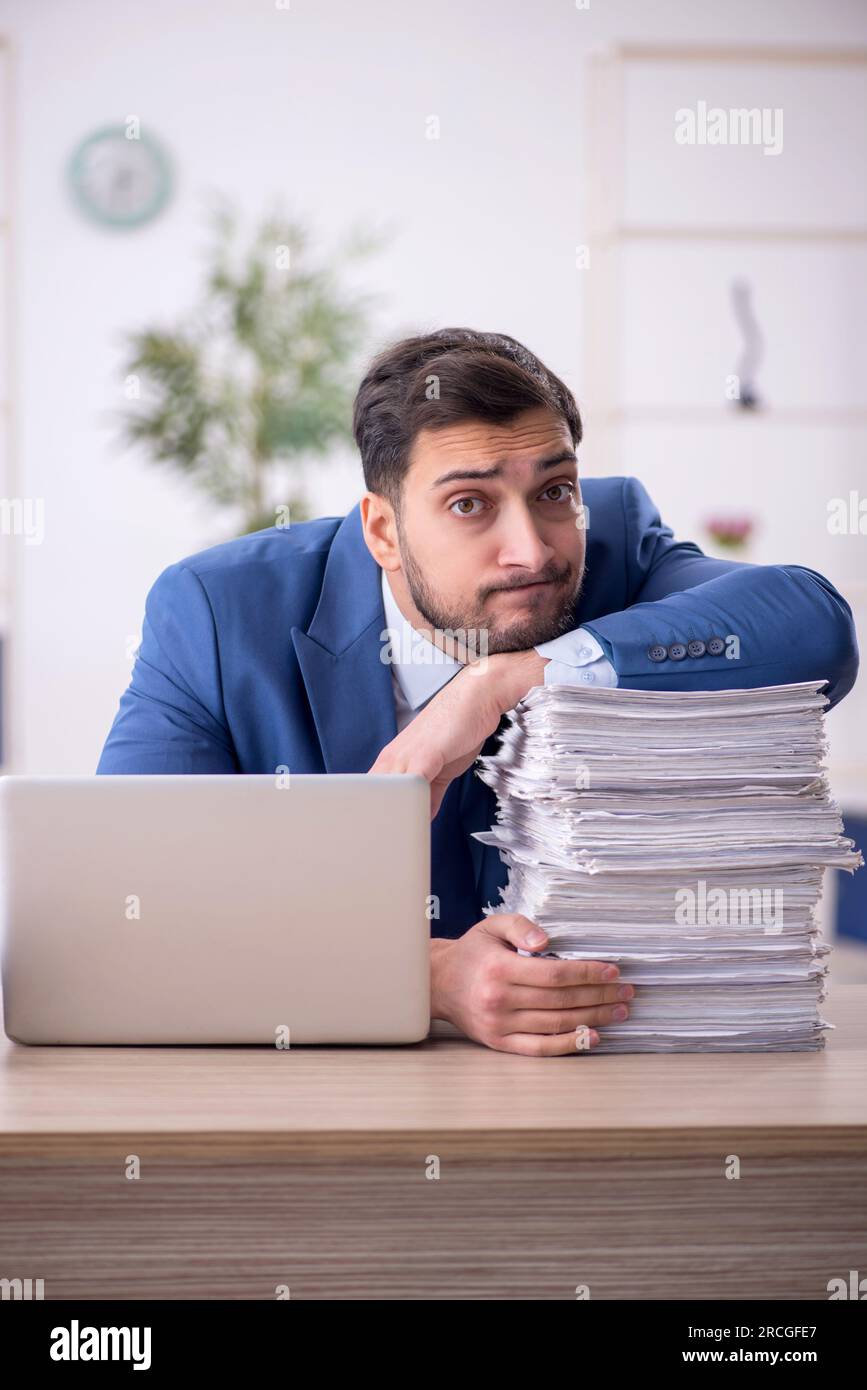 young-employee-and-too-much-work-in-the-office-stock-photo-alamy