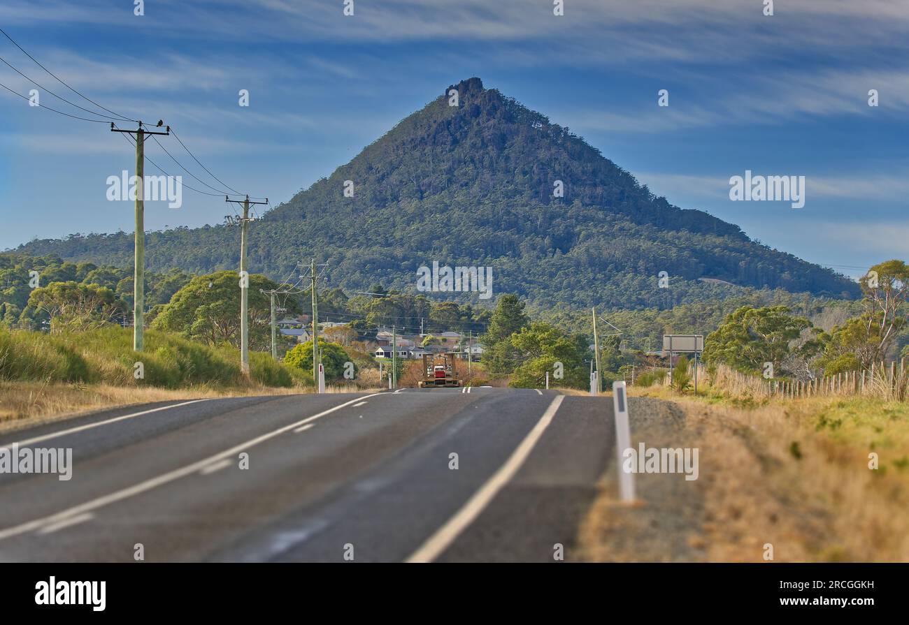 View down the road toward distant St Patrick's Head pyramid shaped mountain peak in St Marys, Tasmania, Australia Stock Photo