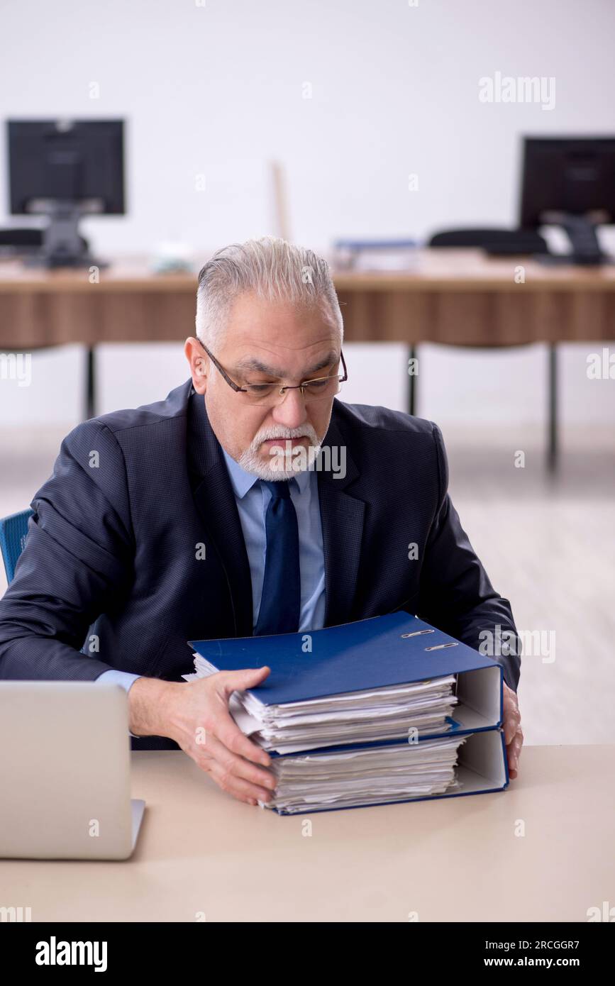 Old businessman employee working at workplace Stock Photo - Alamy
