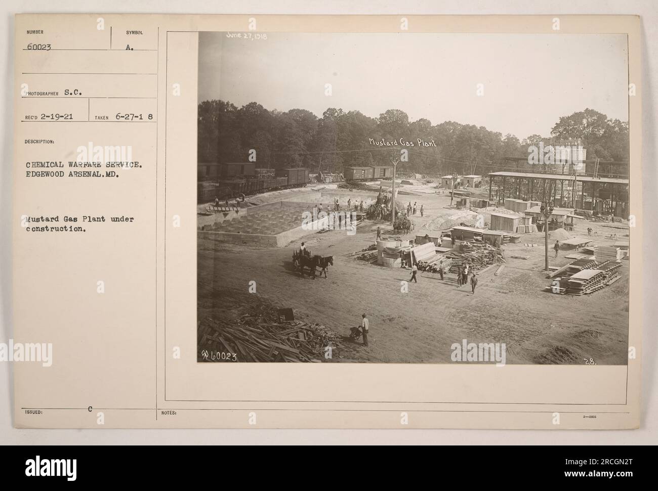 This black and white photograph depicts the construction of a Mustard Gas Plant at Edgewood Arsenal in Maryland. The image, taken on June 27, 1918, shows workers and machinery involved in the building process. The photograph is labeled with a symbol issued by the Chemical Warfare Service. Stock Photo