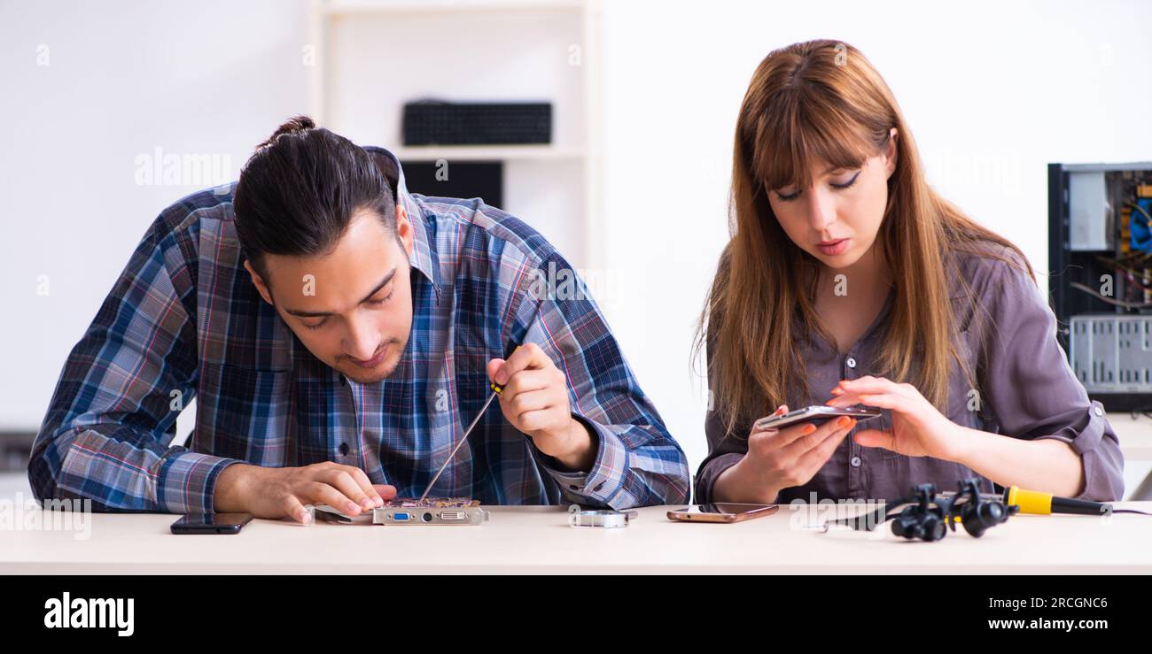 The two technicians working at computer warranty center Stock Photo