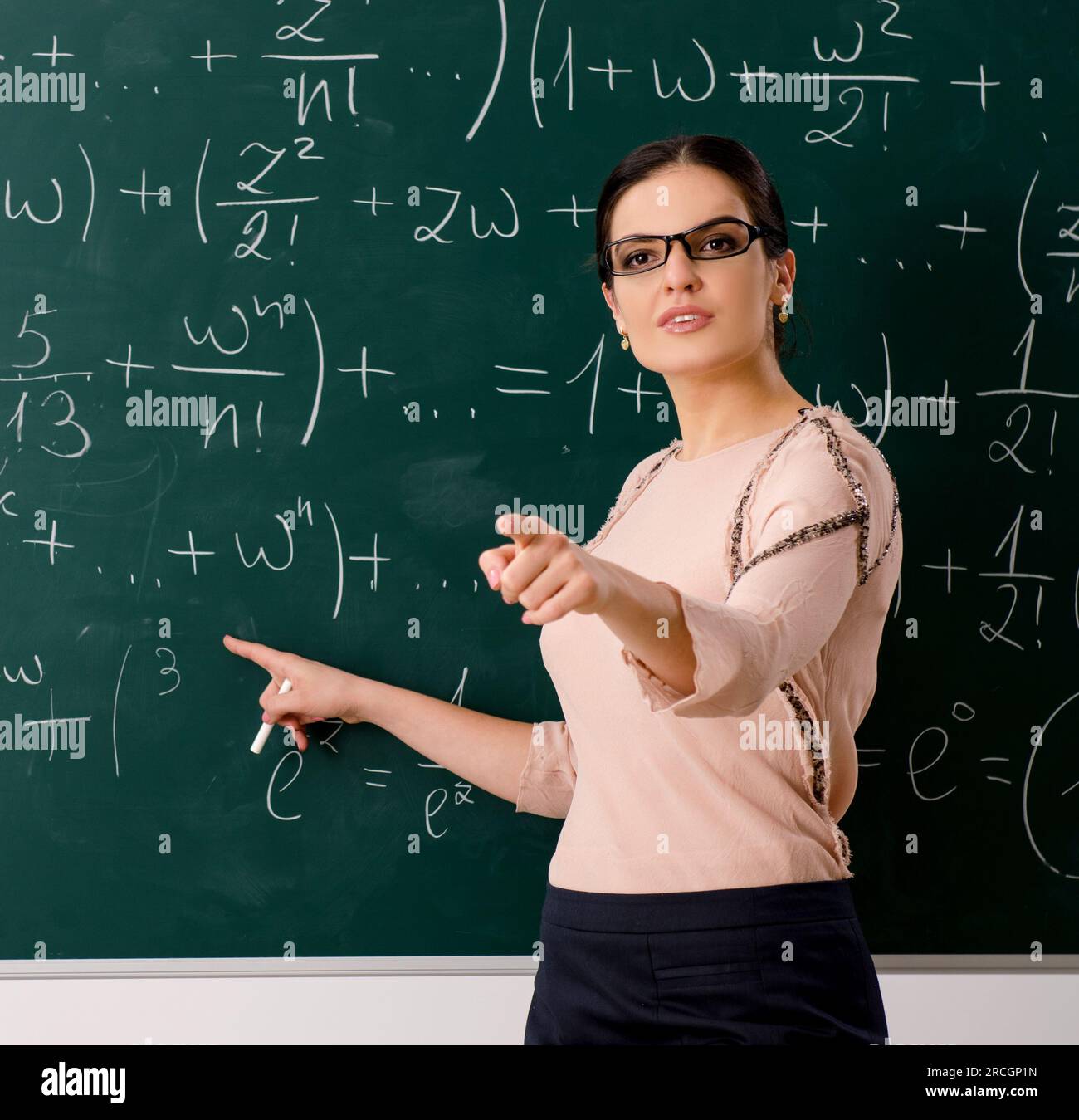 The female teacher standing in front of chalkboard Stock Photo - Alamy