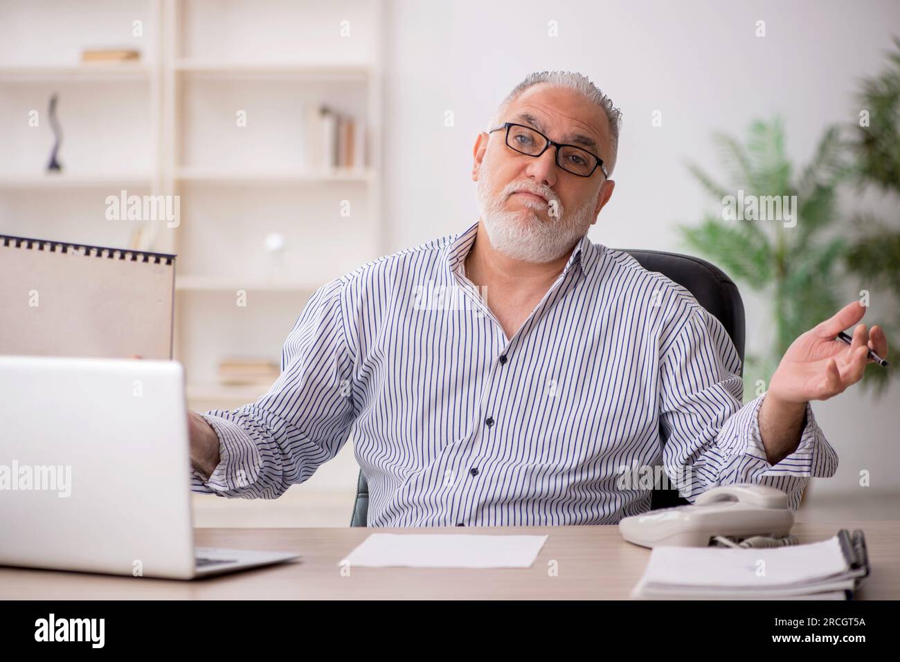 Old employee working in the office Stock Photo