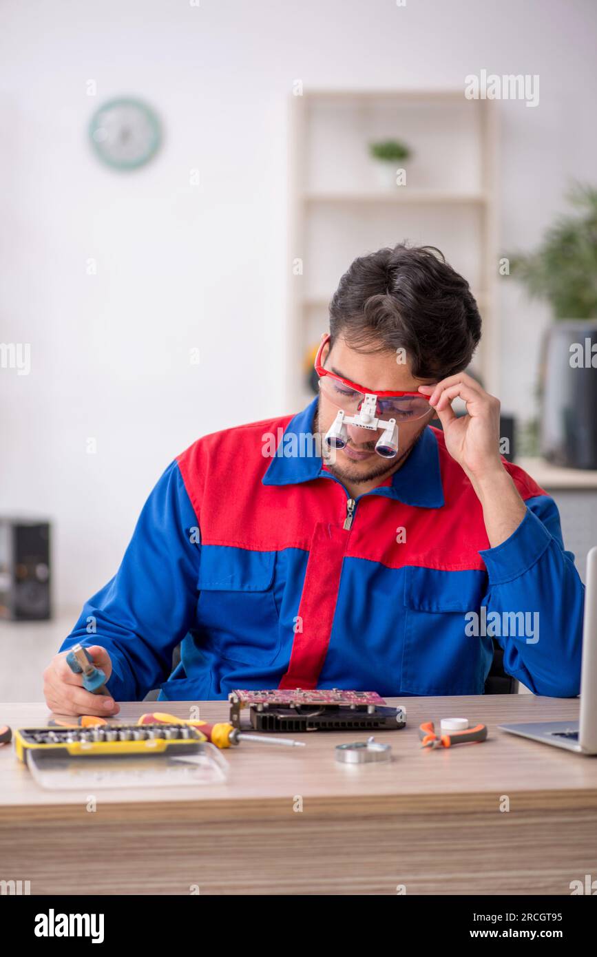 Young repairman repairing computer at the lab Stock Photo
