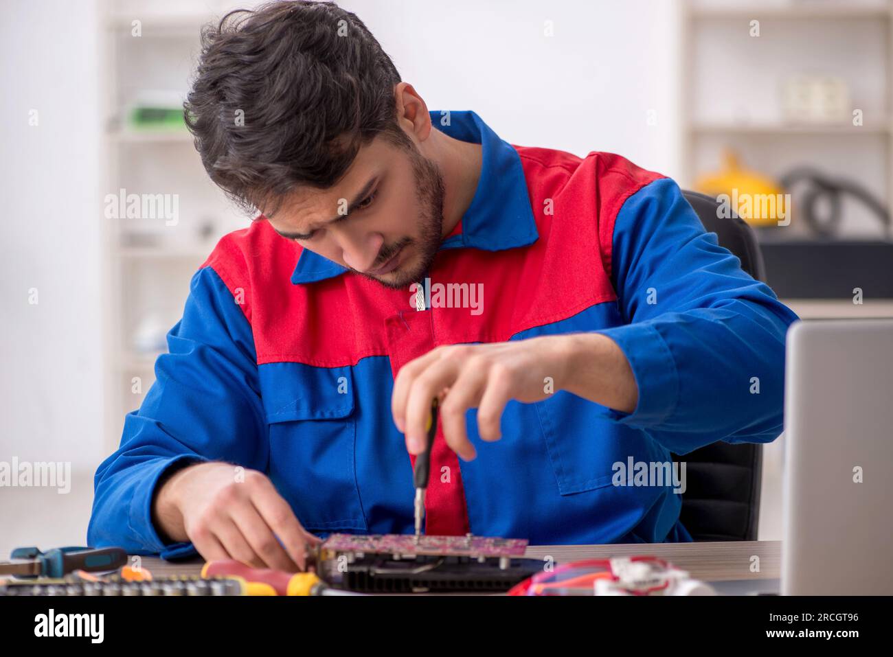 Professional Reparing Lab Young repairman repairing computer at the lab Stock Photo - Alamy