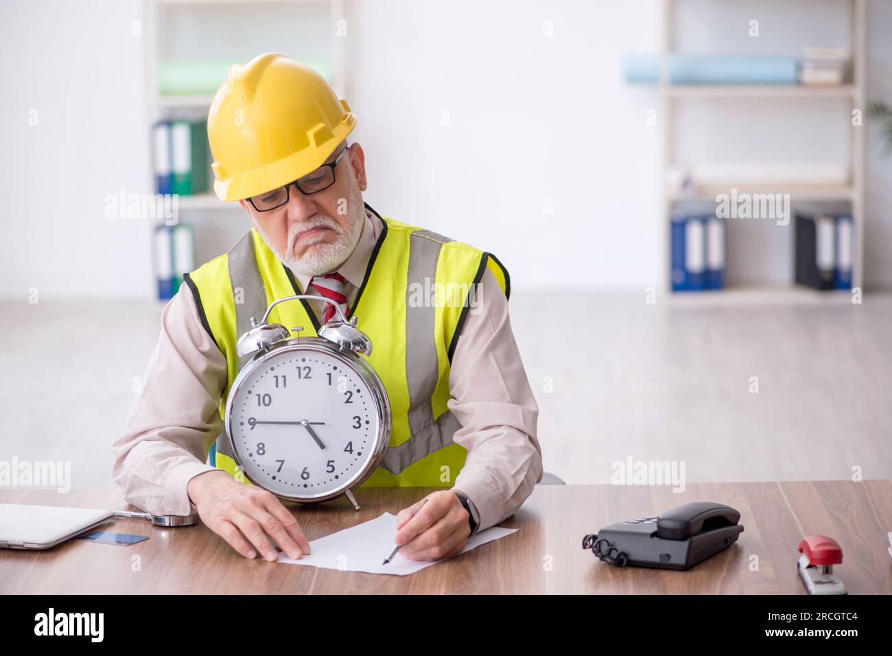 Old architect in time management concept Stock Photo