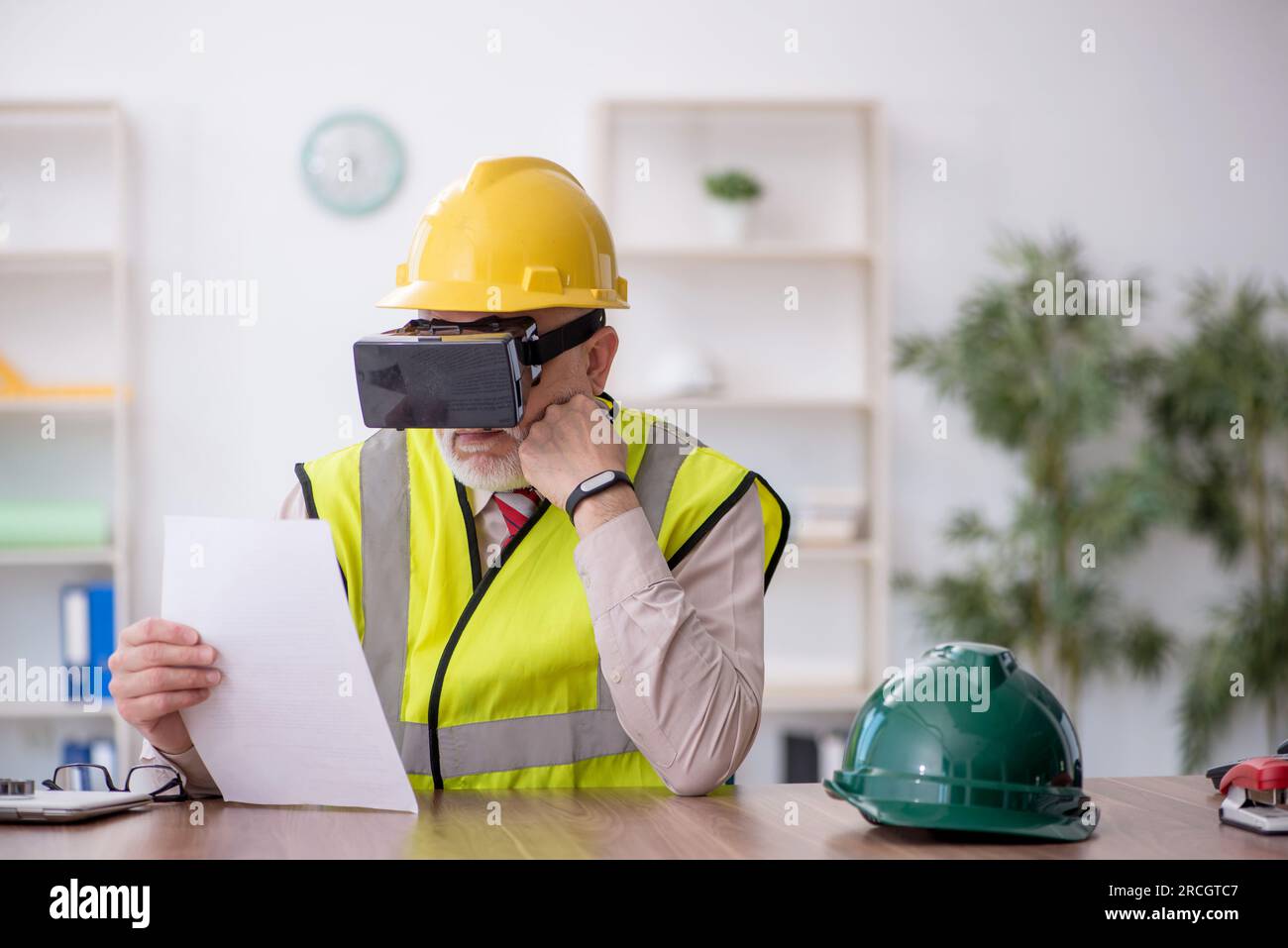 Old architect enjoying virtual glasses at workplace Stock Photo