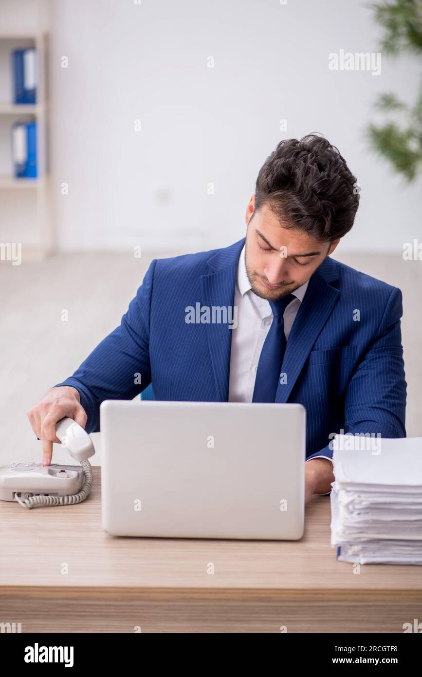 Young employee unhappy with excessive work in the office Stock Photo