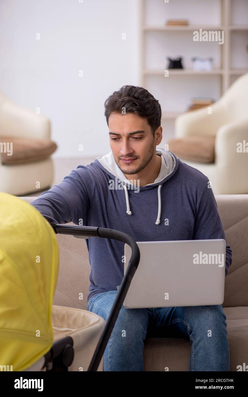 Young male contractor looking after newborn at home Stock Photo
