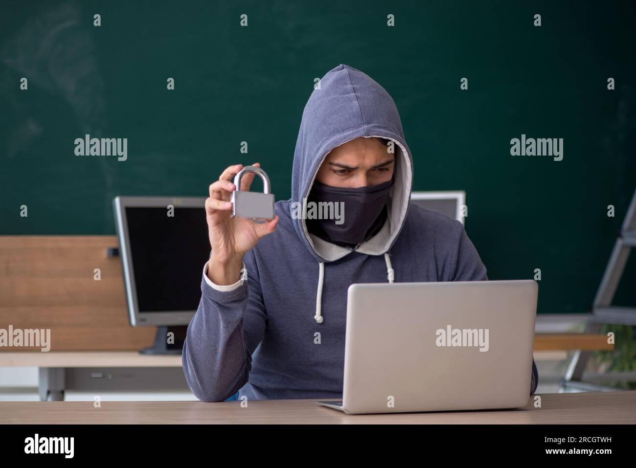 Young hacker sitting in the classroom Stock Photo