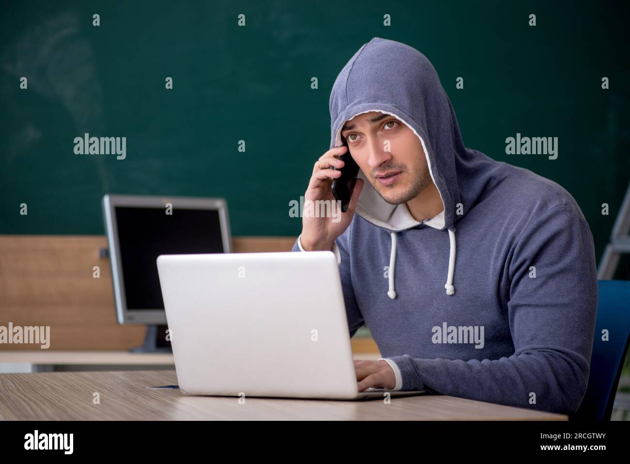 Young hacker sitting in the classroom Stock Photo