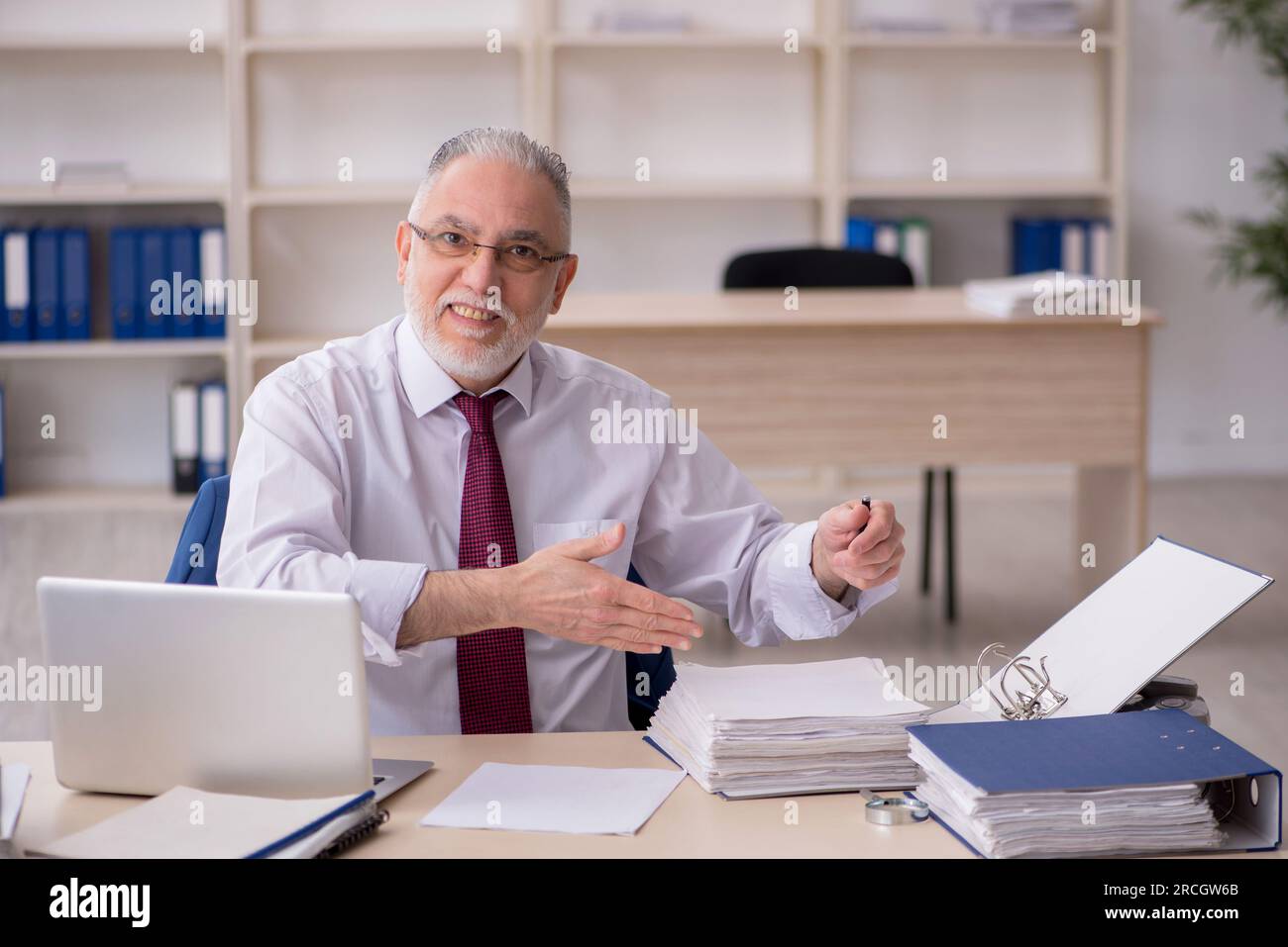 Old employee and too much work in the office Stock Photo