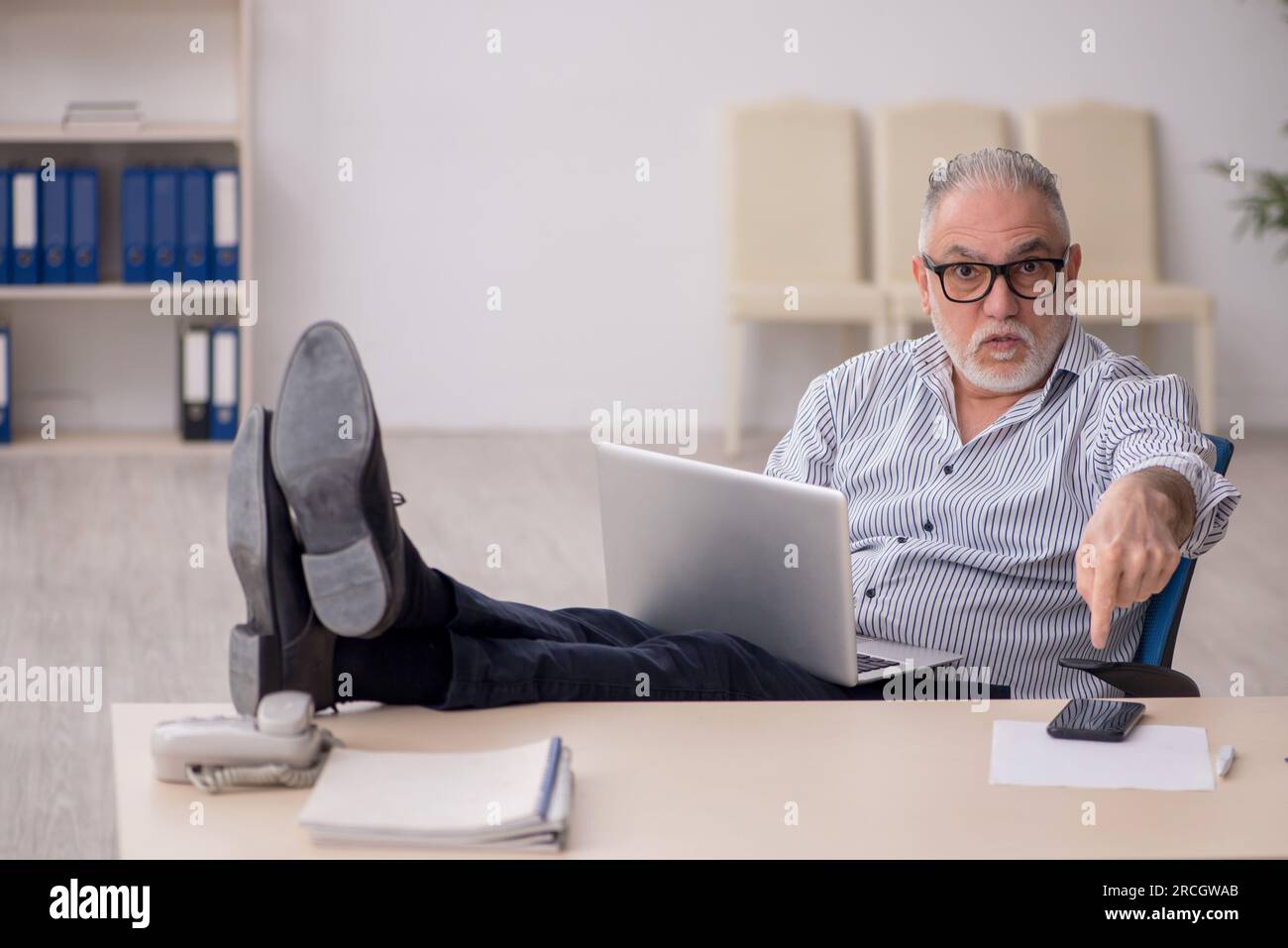 Old employee working at workplace Stock Photo