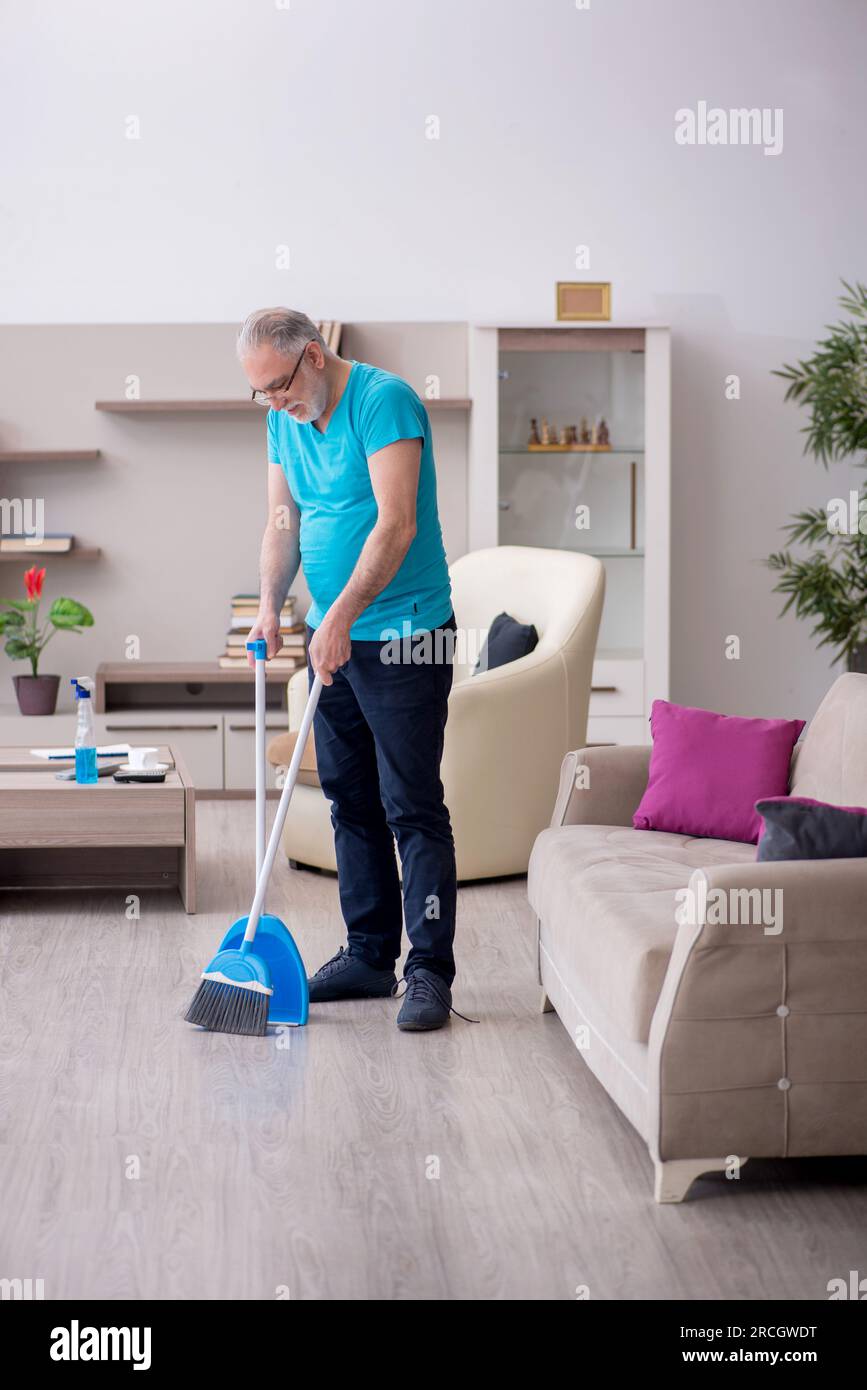 Old contractor cleaning the house Stock Photo