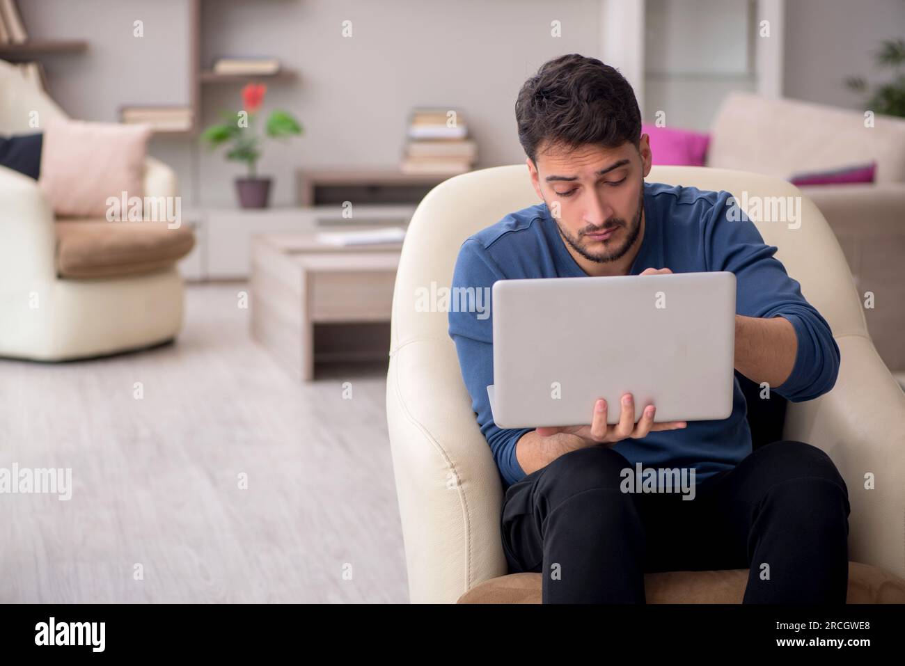 Young male student working from home during pandemic Stock Photo