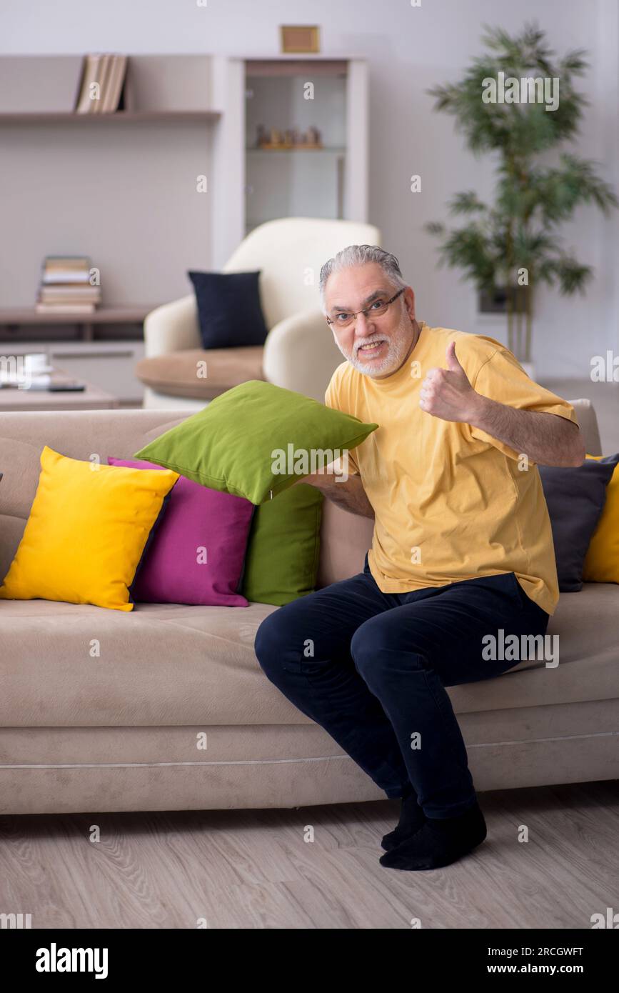 Aged man with many pillows at home Stock Photo