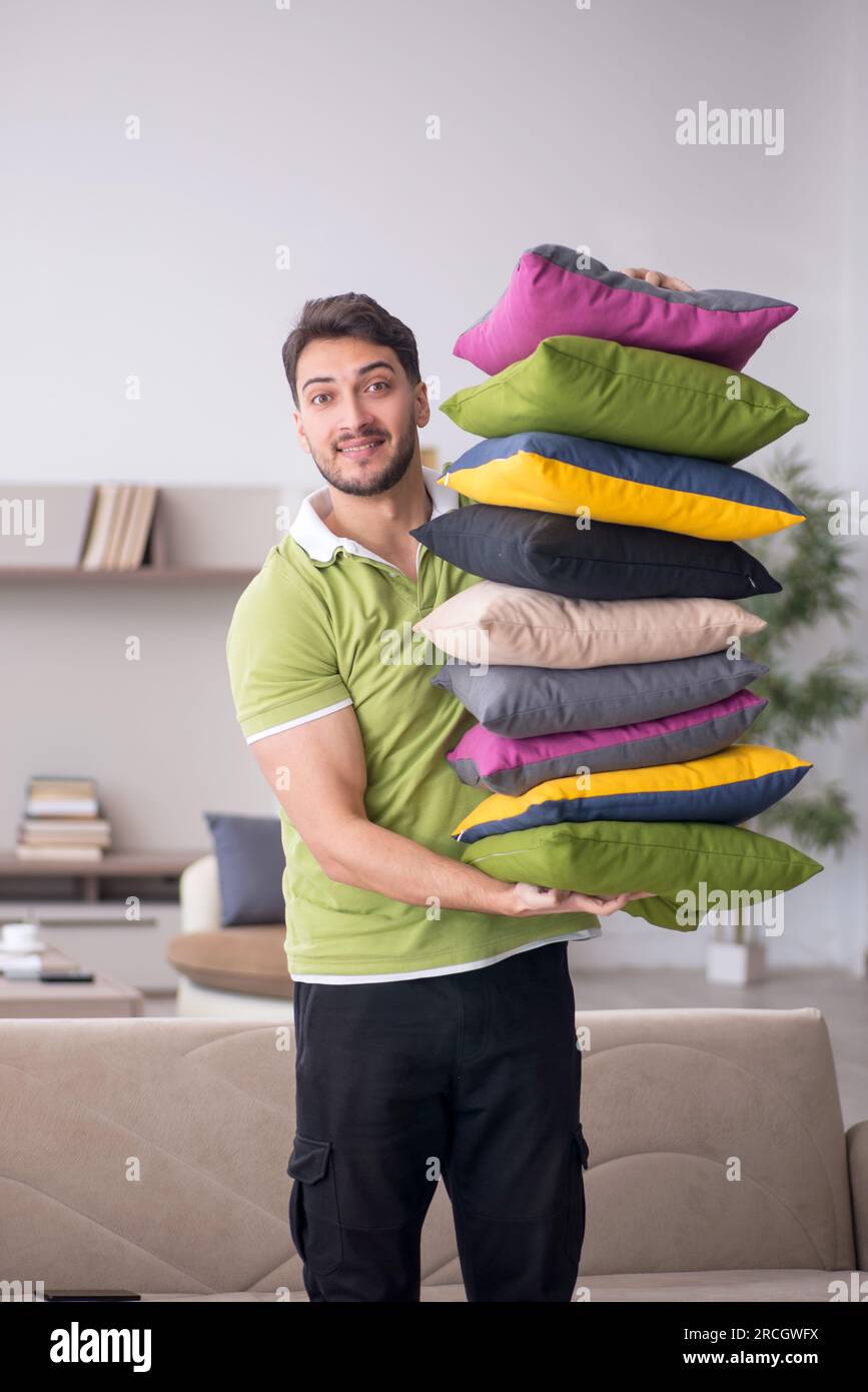 Young man with a lot of pillows at home Stock Photo