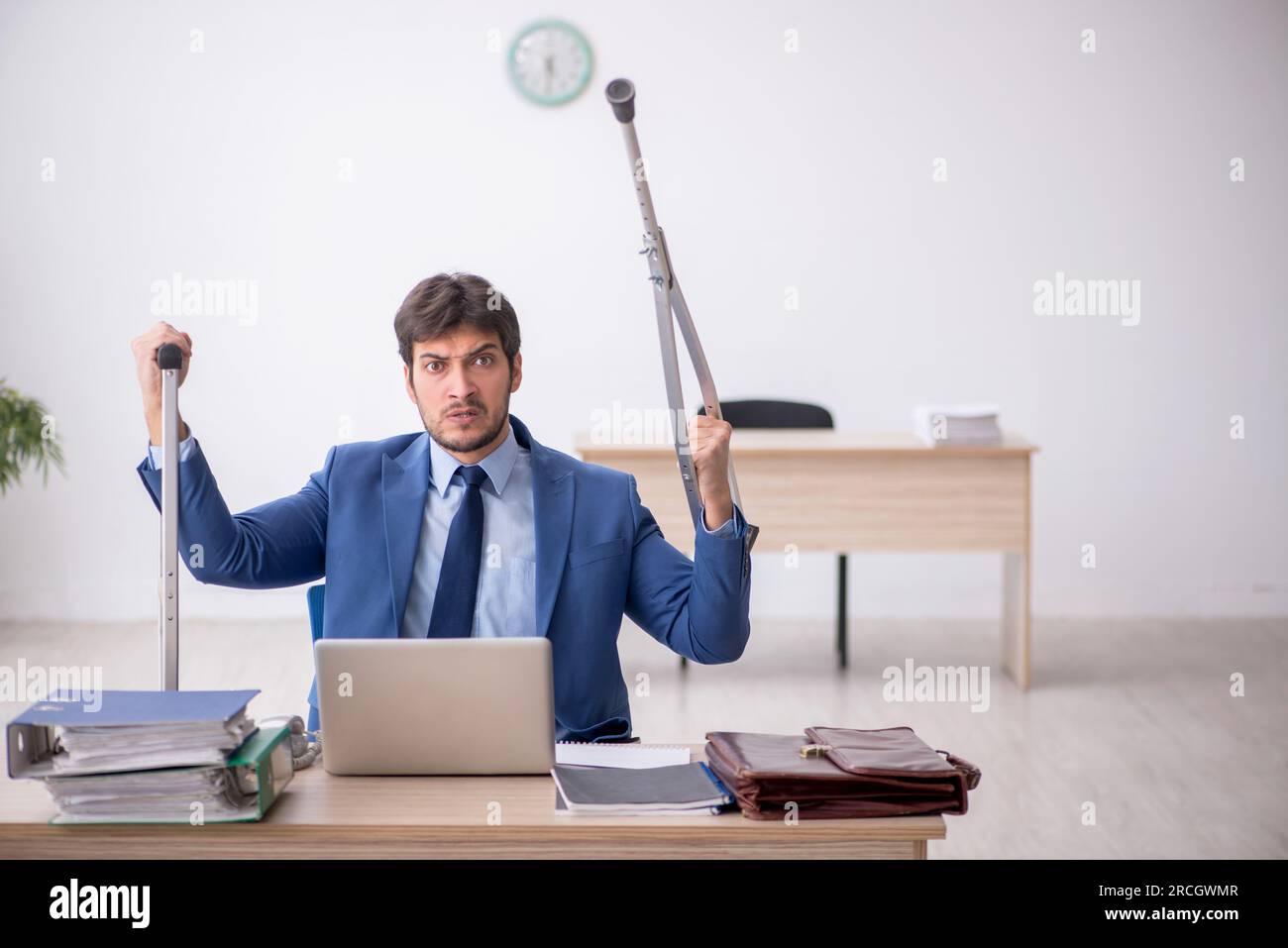 Young employee after car accident sitting at workplace Stock Photo