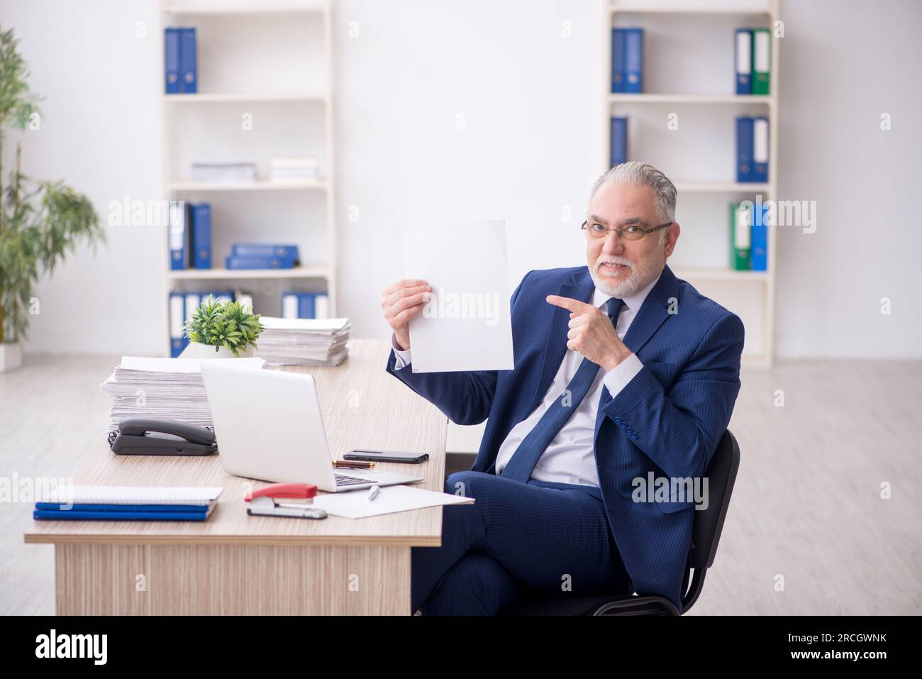 Old businessman employee working at workplace Stock Photo
