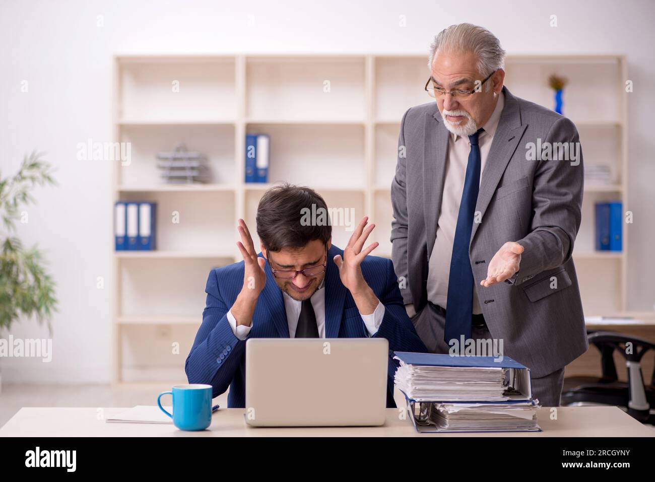 Old boss and young employee in the office Stock Photo - Alamy
