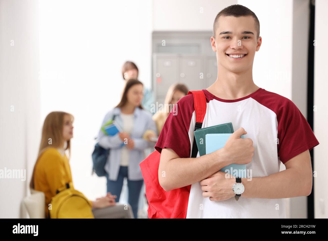 Teenage boy with books at school Stock Photo - Alamy