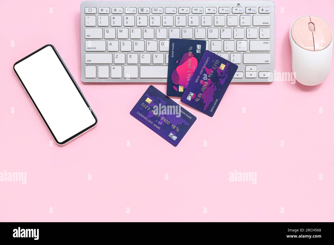 Keyboard with credit cards, computer mouse and mobile phone on pink background Stock Photo